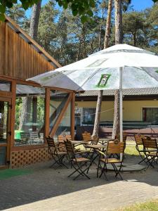 a group of tables and chairs with an umbrella at U Karola in Karpicko