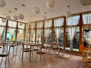 a restaurant with tables and chairs and large windows at U Karola in Karpicko