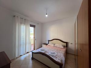 une chambre avec un lit et une grande fenêtre dans l'établissement Reys Central Orikum 2-Bedroom Apartment for Five, à Polisi i Vogël
