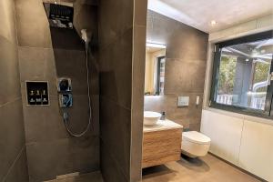 un bagno con lavandino, water e finestra di BlackRock a Stalden Altre 30 foto