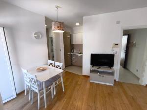 a living room with a table and chairs and a television at Sea view Chiron in Budva