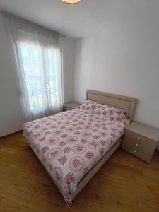 1 dormitorio con 1 cama con manta de flores en Sea view Chiron, en Budva