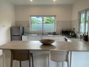 a kitchen with a table with chairs and a sink at Maison Marie Jeanne - Unit 1 in Baie Sainte Anne +2 photos