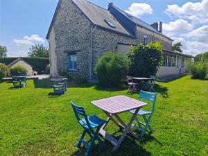 a picnic table and chairs in front of a house at Chambres Les Salles in Beauvoir