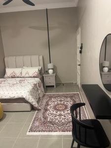 a bedroom with a bed and a chair and a mirror at Yueeda Homestay in Jertih
