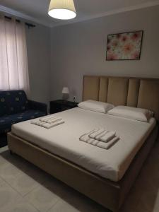 a bedroom with a large bed with towels on it at Cleopatra Apartment in Himare