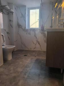 a bathroom with a toilet and a sink and a tub at Cleopatra Apartment in Himare