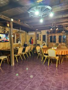 a dining room with wooden tables and chairs at Cabana Dor de-Acas / Restaurant Dor de-Acas in Gura Haitii