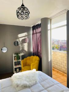a bedroom with a bed and a yellow chair at Cloud 10 Hideaway in Pretoria +34 photos