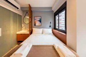 a bedroom with a large bed and a window at BHomy Medeiros in Sao Paulo