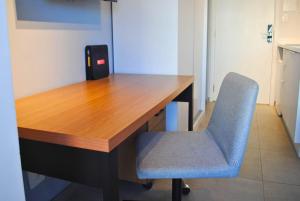 a wooden desk with a blue chair in a room at BHomy Medeiros in Sao Paulo