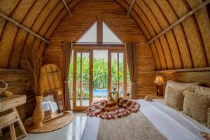 a bedroom with a bed in a room with a window at Penida Green Palm Cottage by Bali Cabin in Toyapakeh +72 photos