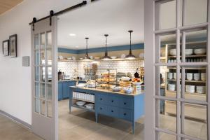 a kitchen with a blue island with food on it at Country Inn & Suites by Radisson, Smithfield-Selma, NC in Smithfield