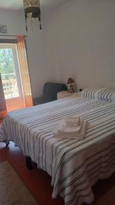 Un dormitorio con una cama grande con una toalla encima. en Casa da Lua, en Erra
