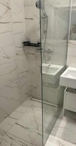 une salle de bain blanche avec une douche et un lavabo dans l'établissement Airport Apartment Okęcie, à Varsovie