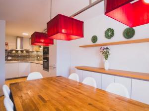 a kitchen with a wooden table and red cabinets at Casa p'ra Muralha in Óbidos