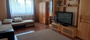 a living room with a television on a wooden entertainment center at Casa Maya in Turda