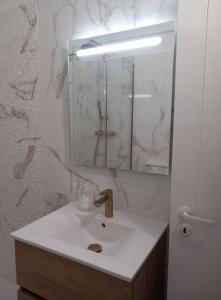 a bathroom with a sink and a mirror at Monte Gordo Beach Sky Flat in Monte Gordo +14 photos