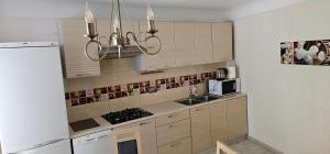 a kitchen with wooden cabinets and a chandelier at Summer in Riga