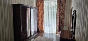 a living room with a large window and a cabinet at Summer in Riga +8 photos