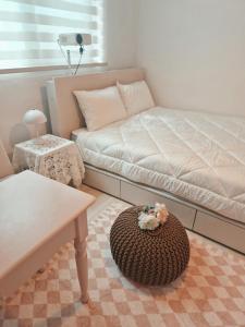 a bedroom with a bed and a ottoman with a table at Daon 101 in Seoul
