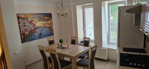 a dining room table with chairs and a painting on the wall at Summer in Riga