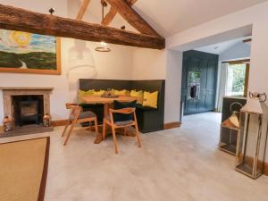 ein Wohnzimmer mit Tisch und Stühlen und einem Kamin in der Unterkunft Welly Bob Cottage in Skipton
