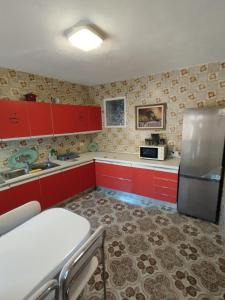 cocina con armarios rojos y nevera de acero inoxidable en Lorca, en Dúrcal