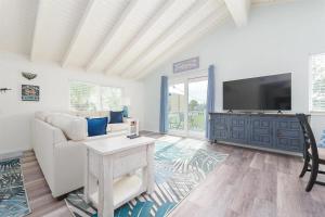 Una sala de estar con un sofá y un televisor. en Beach House Paradise, en St. Augustine