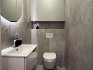 a bathroom with a sink and a toilet and a mirror at URBAN APARTMENTS PREMIUM Sokolska 30A Towers No 28, Free Garage, Gym & Sauna, Self Check-in in Katowice +34 photos