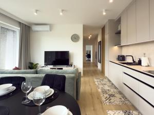 a kitchen and living room with a couch and a table at URBAN APARTMENTS PREMIUM Sokolska 30A Towers No 28, Free Garage, Gym & Sauna, Self Check-in in Katowice