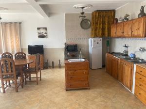 a kitchen with a table and a refrigerator at Villa des Jasmins - Aghroude in Aghoud