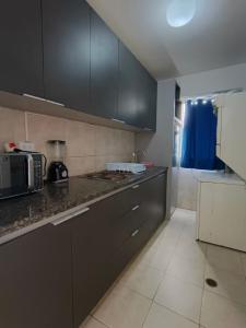 a kitchen with black cabinets and a counter top at Acogedor Apartamento de playa en Los Corales - La Guaira in Caraballeda
