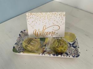 a box of cookies on a plate with a welcome sign at Lùrooms- Guesthouse in Noto in Noto