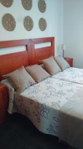 a bedroom with a bed with clocks on the wall at Piso Encanto Palmeiro in Jove +30 photos