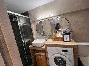 Un baño con lavadora y lavabo. en Antheon Apartment - 1km from the sea, en Néa Michanióna 31 fotos más