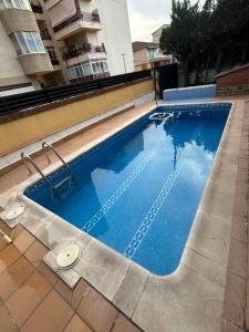 a swimming pool with blue water in front of a building at Chalet in Salou