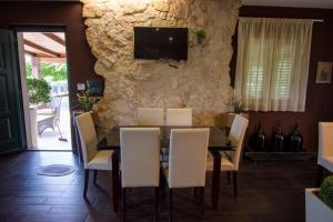 a dining room with a table and chairs and a stone wall at B&B Etna Ranch in Piedimonte Etneo