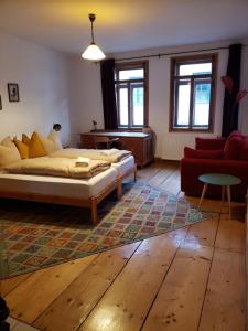 een slaapkamer met een bed en een rode bank bij Pension zum Hirschstein in Greiz