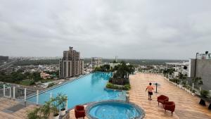 a man standing on top of a building with a swimming pool at The luxurious cozy stay in Jaipur