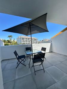 einen Tisch und Stühle auf einem Dach mit einem Regenschirm in der Unterkunft Calahonda Delux in Sitio de Calahonda + 26 Fotos