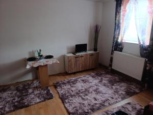 a living room with a table and a tv in it at Ubytování Stráž 2 in Stráž