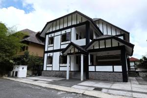 a large black and white building with a driveway at Holiday Bungalow Suites - Sleeps Up To 26 Pax in Tanah Rata