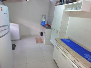 a kitchen with white appliances and a white floor at Casa no centro de Japaratinga in Japaratinga