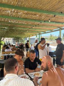 a group of men sitting at a table eating pizza at iCampJal Beach Camp and Bar in Jal