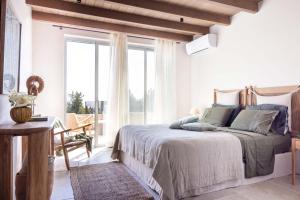 a bedroom with a bed and a large window at Bacchetta Magica by PaxosRetreats in Gaios