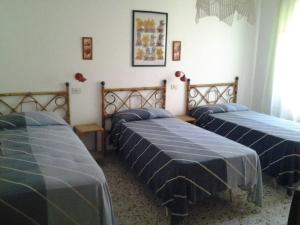 three beds in a room with blue sheets on them at Casa Marverde in Cinquale