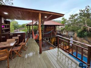 une terrasse en bois avec un hamac et une aire de jeux dans l'établissement Caminito del Sol Cabaña cerca al mar en Palmarito, à Carretal