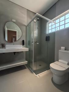 a bathroom with a shower and a toilet and a sink at Pousada Porto do Sol in Pôrto Rico +34 photos