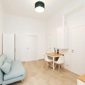 ein Wohnzimmer mit einem Tisch und einem blauen Sofa in der Unterkunft Casa Celeste b&b Navigli in Mailand